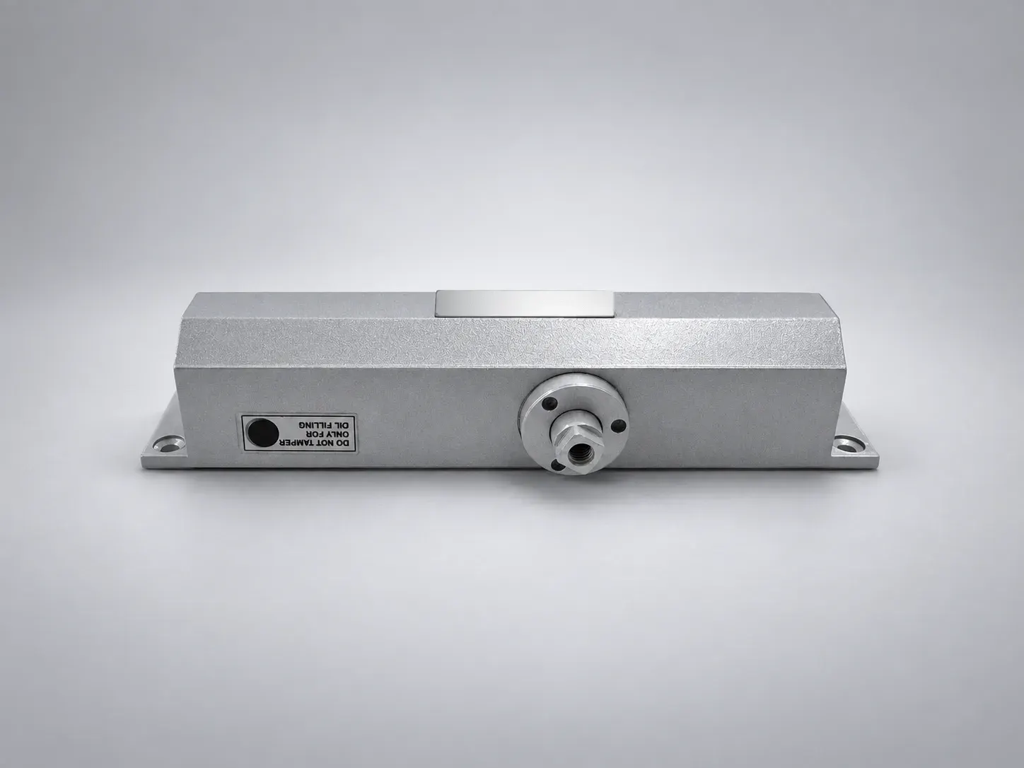 Sterling DC 1500 door closer body, front view with the oil filling sticker and the spindle, studio photograph