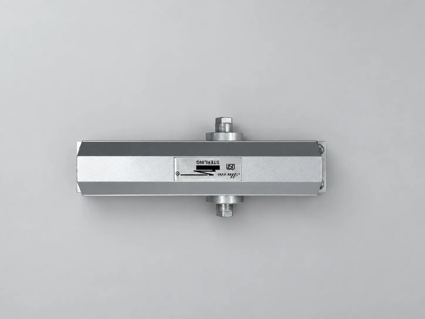 Sterling DC 1500 door closer body seen from above, with its label plate on the extruded body and the spindle at both sides, studio photograph