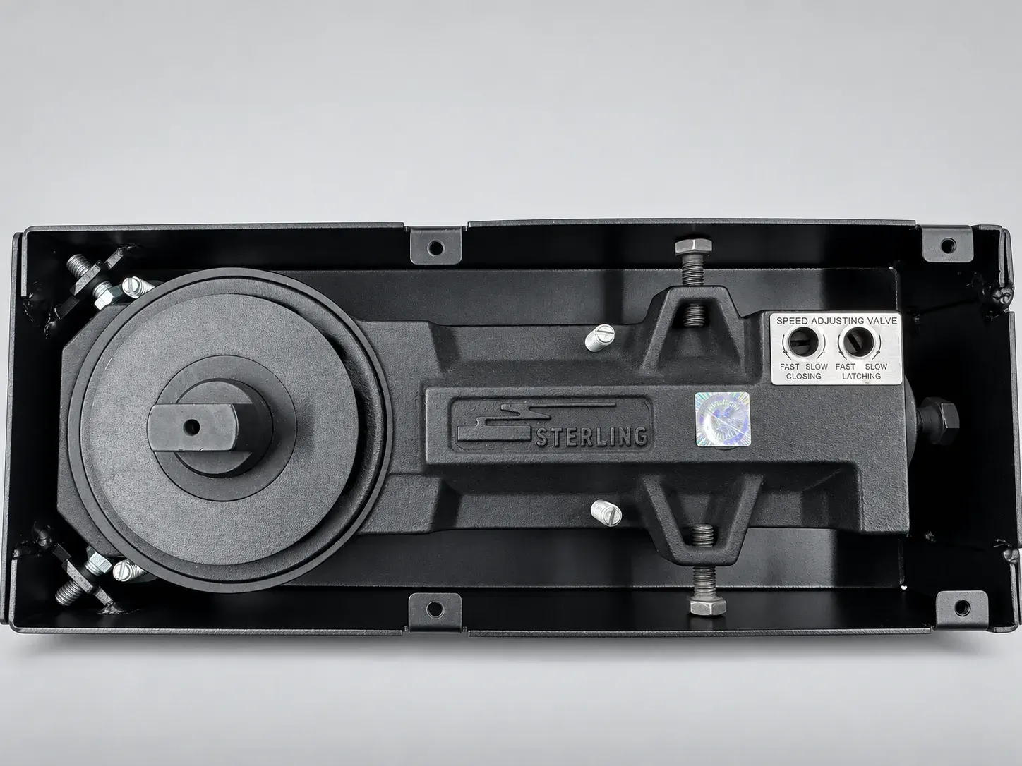 Sterling FS 1000 floor spring, close top view of the cast Sterling body and the speed adjusting valve plate for closing and latching, cover plate removed, studio photograph