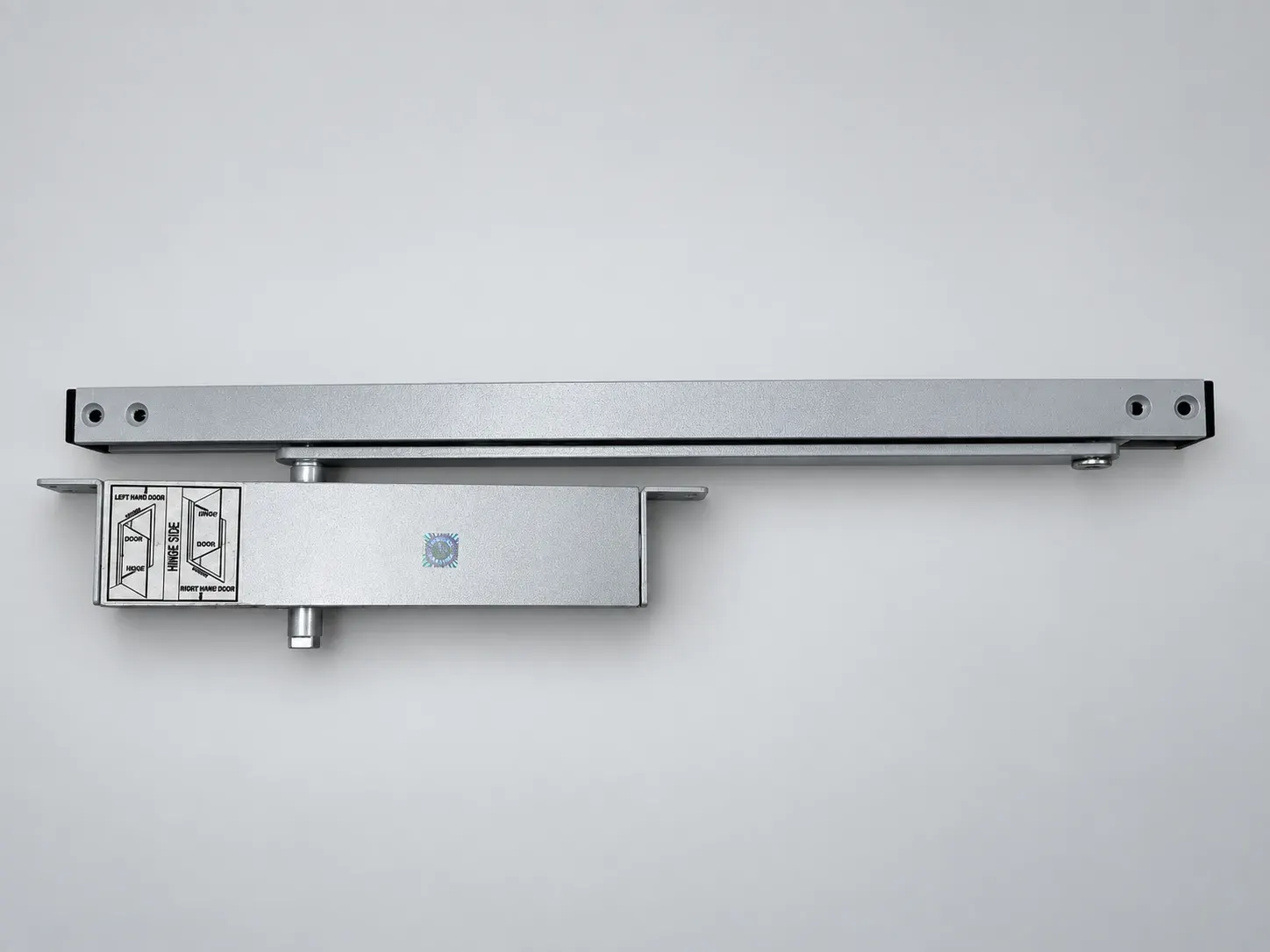 Sterling concealed door closer body with its slide track and the hinge side handing label, silver, front view, studio photograph